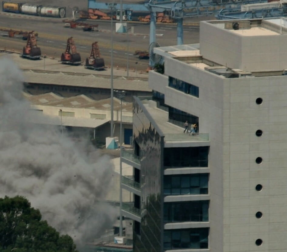 A Hizbullah rocket explodes near the Haifa port, sending Israelis scrambling for safety atop a nearby high-rise building 2006 (AP Photo/Baz Ratner)